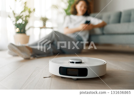 White robotic vacuum cleaner on wooden floor 131636865