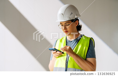 Woman architect on white wall background Woman architect on white wall background 131636925