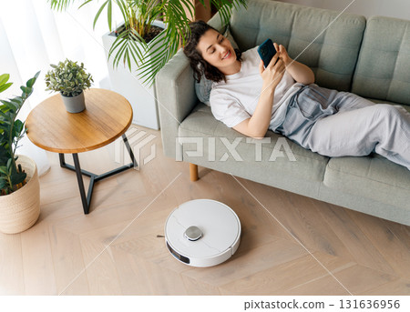 White robotic vacuum cleaner on wooden floor White robotic vacuum cleaner on wooden floor 131636956