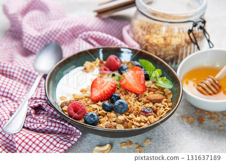 Granola yogurt parfait with fresh berries and honey 131637189