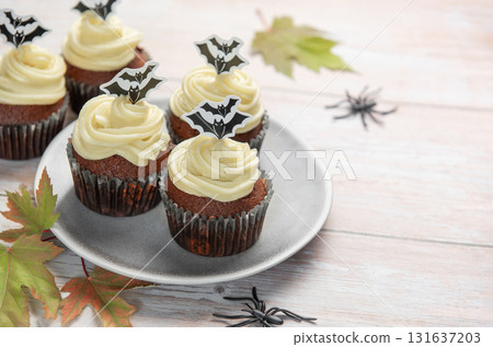 Halloween cupcakes with bat toppers and autumn leaves Halloween cupcakes with bat toppers and autumn leaves 131637203