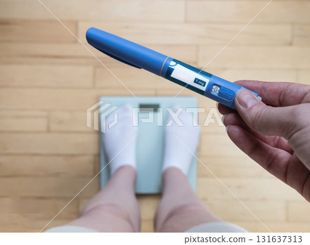 Ozempic Insulin injection pen for diabetics and weight loss. Woman weighs herself and holds Ozempic in her hand. Ozempic Insulin injection pen for diabetics and weight loss. Woman weighs herself and holds Ozempic in her hand. 131637313