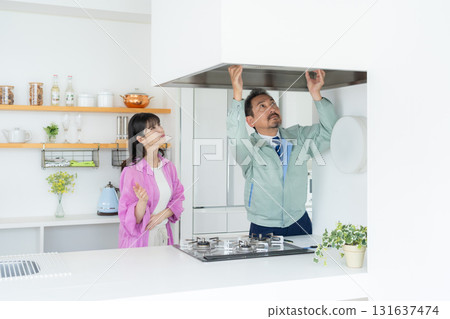一名房地產經紀人和一名中年婦女在廚房做維修工作 131637474