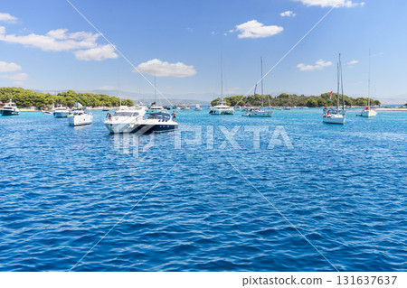 Boats and yachts anchoring in a clear Croatian bay Boats and yachts anchoring in a clear Croatian bay 131637637