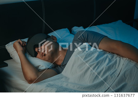 a man sleeping with a sleep mask in a bedroom 131637677