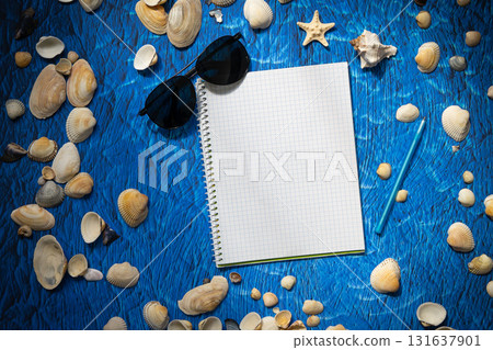 flat lay on blue background blank notebook copy space. summer plans concept 131637901