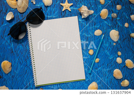 flat lay on blue background blank notebook copy space. summer plans concept 131637904