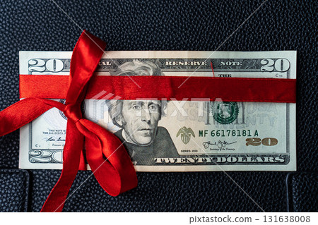 Money as a birthday present gift with red ribbon, dollar present Money as a birthday present gift with red ribbon, dollar present 131638008