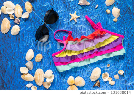 accesories for summer sea beach on blue wawes background. Beach things sunglasses and swim suit 131638014