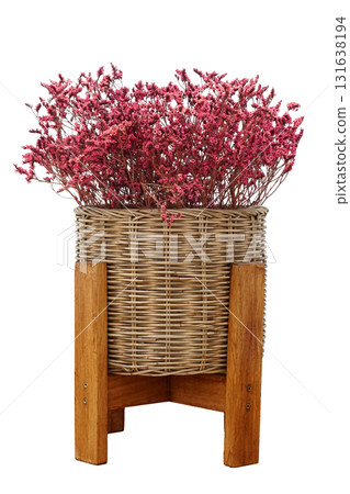 A bouquet of red dried flowers in a woven wicker basket. With a wooden stand for home interior decoration isolated on white background 131638194