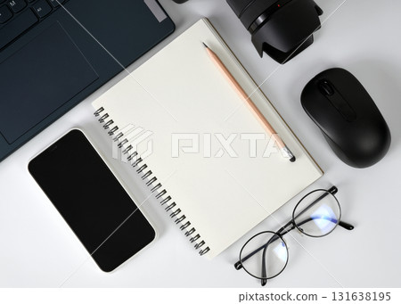 Minimalist style white working top table flat lay with blank notebook pages surrounded by modern lifestyle gadgets electronic devices Minimalist style white working top table flat lay with blank notebook pages surrounded by modern lifestyle gadgets electronic devices 131638195