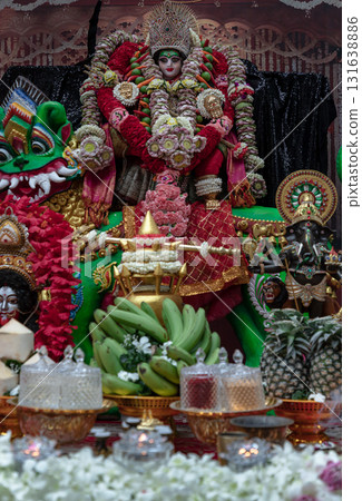 The idol of Goddess Ambika, the deity heavily adorned with flowers, garlands, and other decorations, The display is a form of worship and a way to celebrate the Navaratri festival. The idol of Goddess Ambika, the deity heavily adorned with flowers, garlands, and other decorations, The display is a form of worship and a way to celebrate the Navaratri festival. 131638886