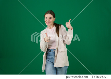 Set of photos of young European woman in light blazer and blue jeans showing various emotions gestures and expressions on green chroma key background with copy space for advertising and social media 131639070