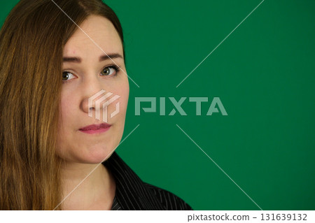 Emotional young European woman on green background biting lip and looking up with teary eyes feeling sad and worried with copy space for text or advertising Emotional young European woman on green background biting lip and looking up with teary eyes feeling sad and worried with copy space for text or advertising 131639132