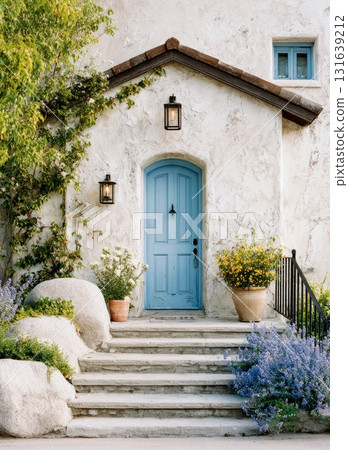 White stucco house entrance with blue door 131639212