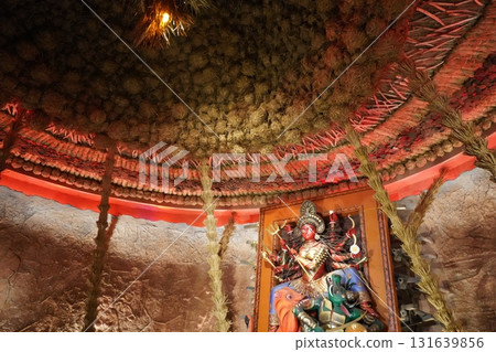 Conceptual Durga Idol in Rustic Straw Hut Pandal with Red Lighting 131639856
