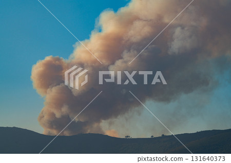 Large Smoke Plume Rising Over Scenic Landscape Large Smoke Plume Rising Over Scenic Landscape 131640373