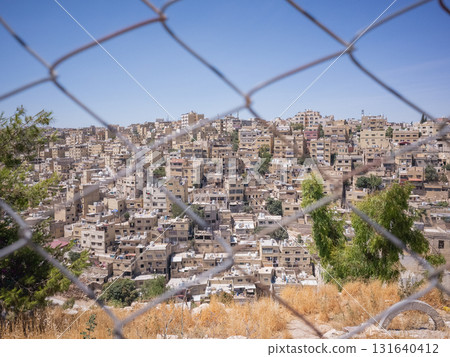 [Jordan] A streetscape of densely packed stone houses seen through the wire fence of Amman Citadel in downtown Amman, the capital city 131640412