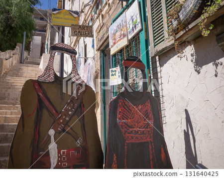 [Jordan] A panel depicting people in traditional clothing is set up on a street in downtown Amman, the capital of Jordan. 131640425