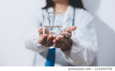 Portrait of Asian doctor woman standing holding coffee cup in white studio background 131640700