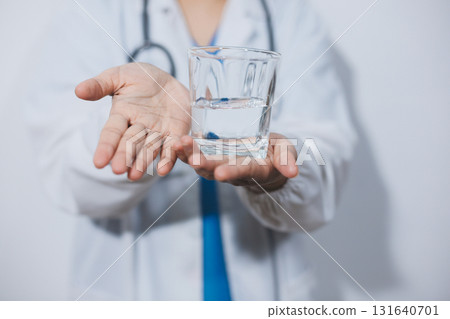Portrait of Asian doctor woman standing holding coffee cup in white studio background Portrait of Asian doctor woman standing holding coffee cup in white studio background 131640701
