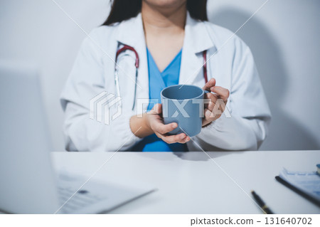 Female scientist holding coffee mug in laboratory 131640702