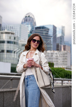 Woman holding coffee cup modern city 131641534