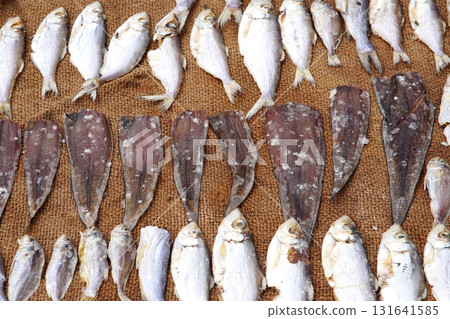 Fresh fish drying outdoors in the bright sunlight 131641585