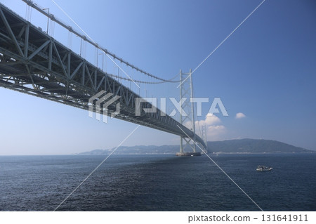 藍色的大海、船隻、明石海峽大橋、淡路島、白雲和藍天的風景 131641911