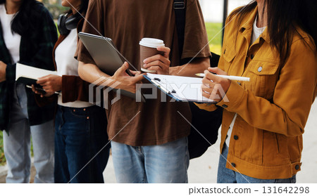 Happy students walking together on university campus, chatting and laughing outdoors after classes 131642298