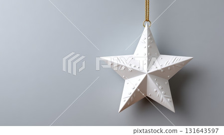 White star ornament hanging against a plain background 131643597