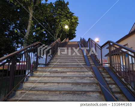 The staircase leading up, deserted at dusk surrounded by a tree, is beautiful and atmospheric The staircase leading up, deserted at dusk surrounded by a tree, is beautiful and atmospheric 131644163