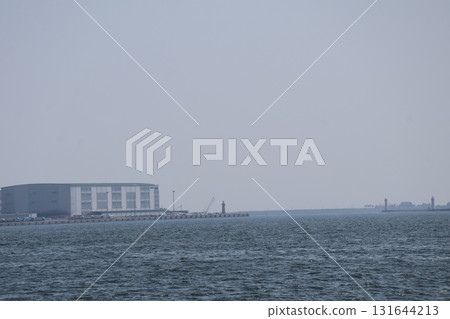 Blue sea surface, coastal buildings, jetty, horizon and sky 131644213