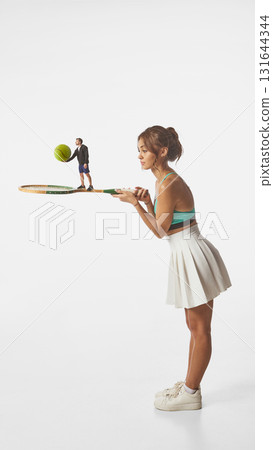 Modern artwork. Tiny man standing on tennis racket held by woman 131644344