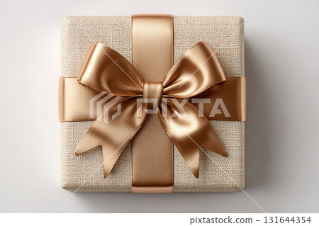 Birthday gift. Top view. Elegant square gold box wrapped with a silver bow on white background. Jewelry, birthdays and luxury branding. Birthday gift. Top view. Elegant square gold box wrapped with a silver bow on white background. Jewelry, birthdays and luxury branding. 131644354