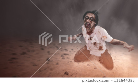 Indonesian southeast asian scary male zombie with a wound and bloody crawling in a gravel field. The scene is scary and creepy. Dramatic smoke or fog effect. Concept of Spooky Halloween 131644383