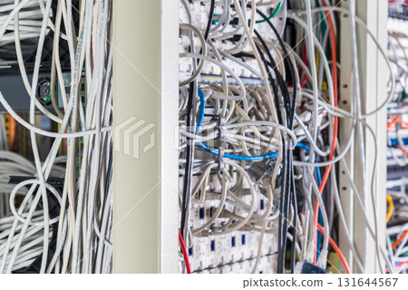 server room rack with tangled network cables creating messy unti 131644567