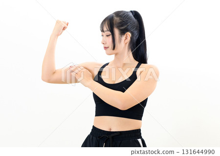 酷酷的女人在鍛煉，鍛鍊二頭肌，進行肌肉訓練，運動胸罩，白色背景，短款 131644990