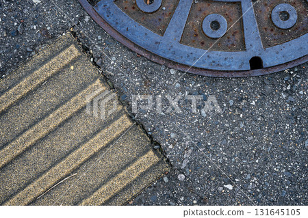 Manholes and tactile paving at the foot of the city | Close-up texture capturing the texture of the pavement and infrastructure 131645105