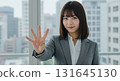 一位穿著西裝的女士將右手向前舉起 131645130