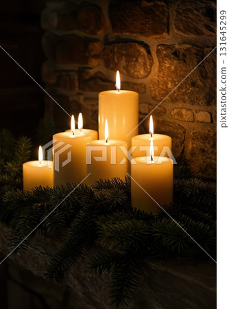 Cozy Hygge Christmas Fireplace Mantel with Glowing Pillar Candles and Evergreen Garland Cozy Hygge Christmas Fireplace Mantel with Glowing Pillar Candles and Evergreen Garland 131645299