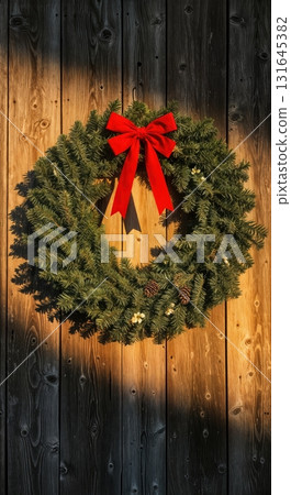 Rustic Farmhouse Christmas Wreath with a Red Bow on a Weathered Barn Wood Door at Sunset 131645382
