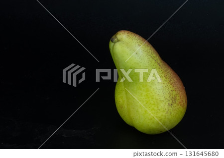 Single Green and Red Corella Pear Isolated on Black. Natural Sweet Snack. Single Green and Red Corella Pear Isolated on Black. Natural Sweet Snack. 131645680