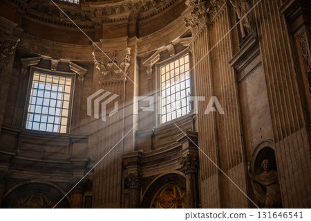 Sunlight rays shining through historic cathedral windows illuminating ornate architectural details 131646541