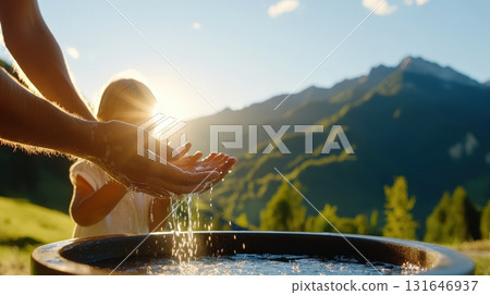 Parent and child sharing a tender moment as they wash hands together in a serene picturesque mountain landscape at sunrise or sunset  The scene conveys a sense of care education 131646937