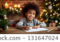 Happy African American 7 years old boy writing dear Santa letter in his room with Christmas decoration. 131647024