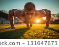 Determined athlete caught mid-push-up at sunrise on track field 131647673