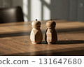 Rustic salt and pepper shakers glow warmly in natural daylight shadows 131647680