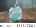 Effervescent sparkling water bubbles rise in delicate glass with ice 131647681