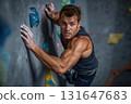 Determined climber ascends colorful textured wall with chalked hands and focused eyes 131647683